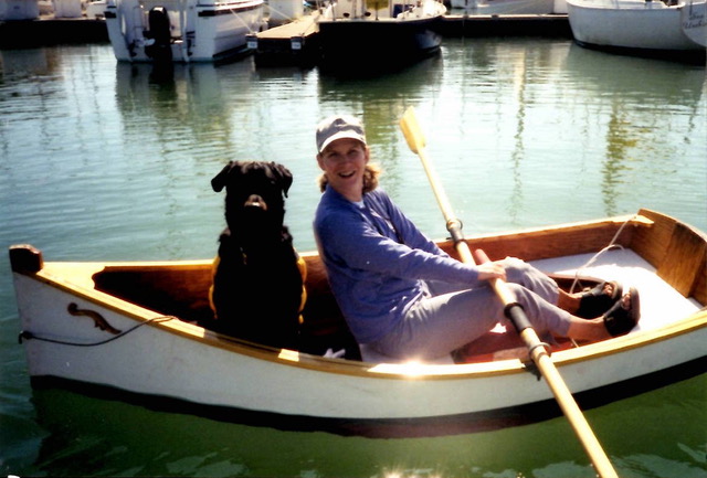 Woman and black dog in a row boat